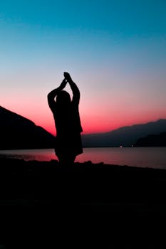 日落时分，湖边的宁静剪影中站着一个人