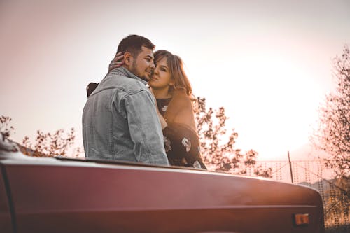 Free Man and Woman Leaning on Car Stock Photo