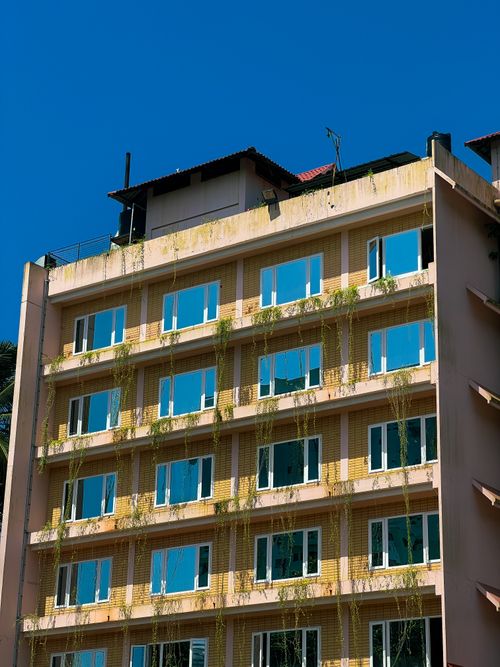 Free Sunny facade of a contemporary apartment building with lush greenery in Kozhikode, Kerala. Stock Photo