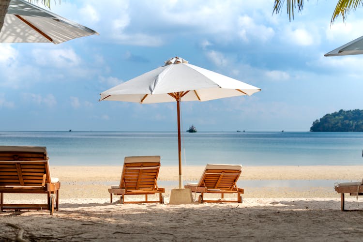 Tropical Beach With Deckchairs And Umbrella