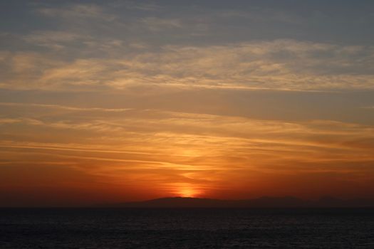 A tranquil view of a Mediterranean sunset with a warm, calming atmosphere.