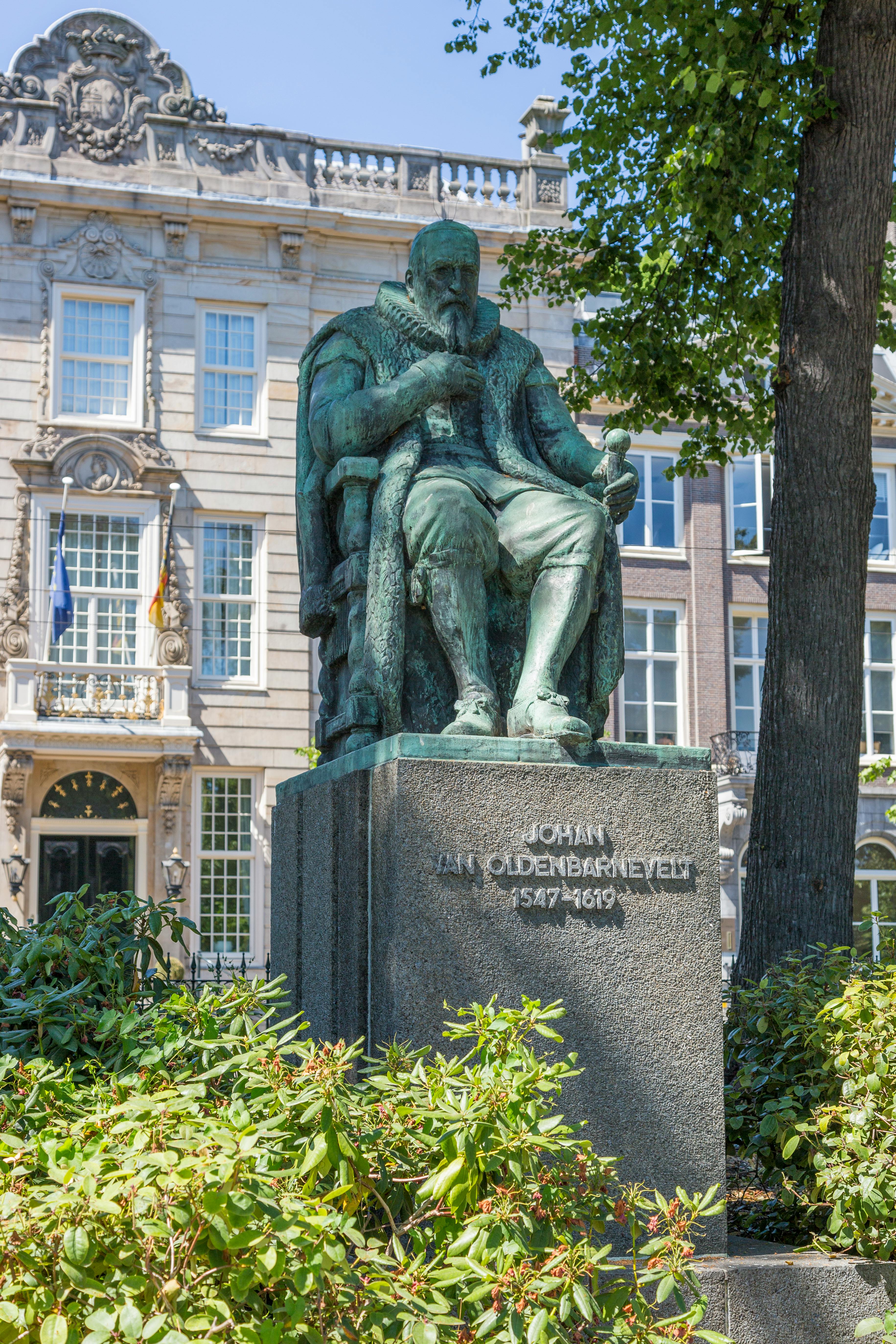 Bronze statue of Johan van Oldenbarnevelt with historic architecture in Amsterdam.