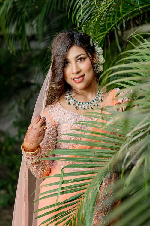 Free A beautiful woman in traditional attire surrounded by lush tropical leaves, exuding elegance and grace. Stock Photo