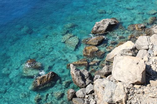 Free A breathtaking view of Greece's rocky coastline and clear turquoise sea. Stock Photo
