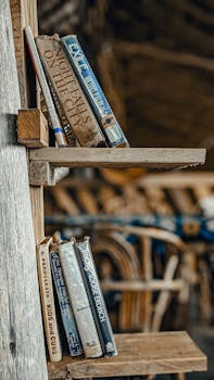 A collection of vintage books displayed on a rustic wooden shelf in a cozy indoor setting in Moshi, Tanzania.