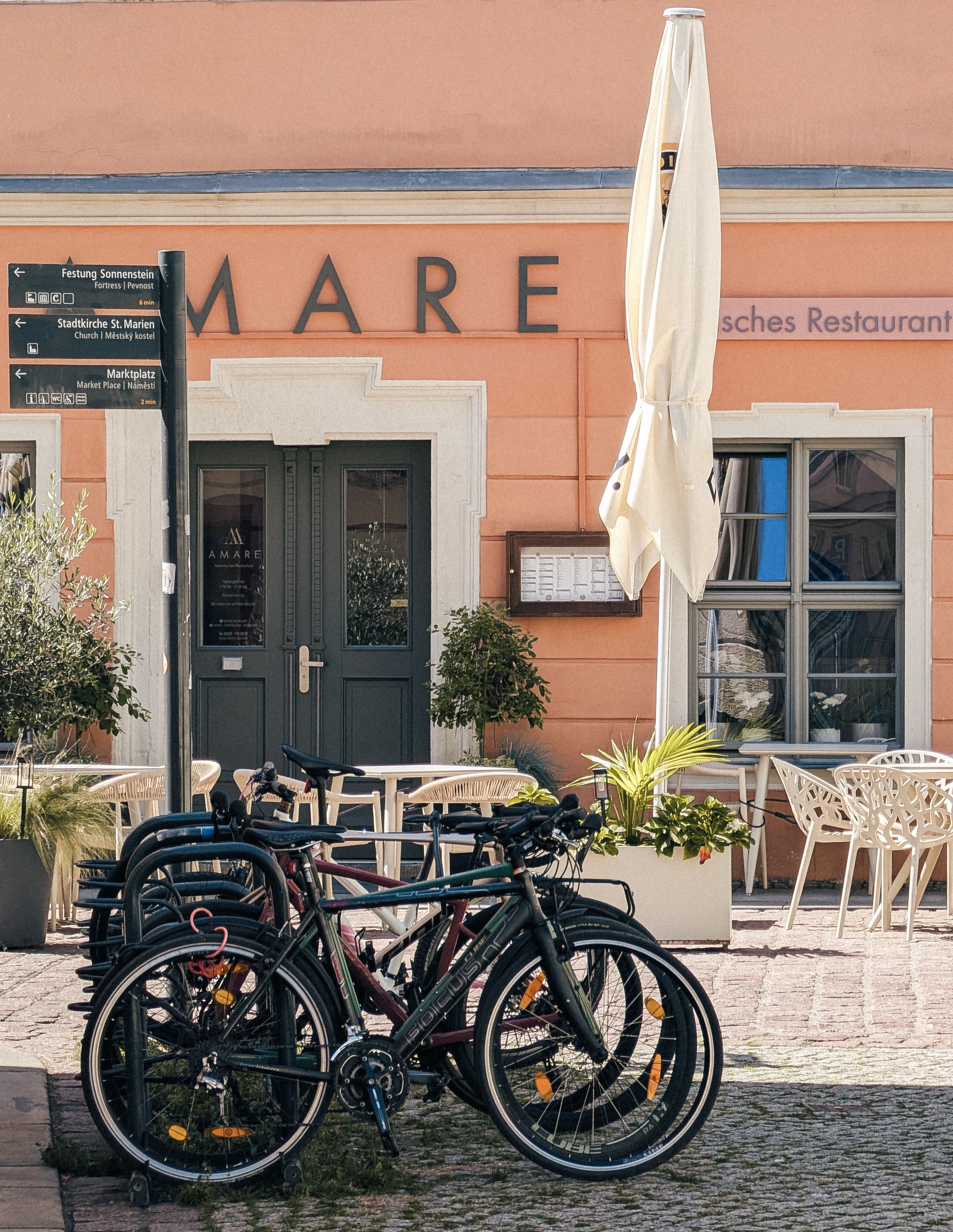 Bicycles parked by a restaurant in sunny Pirna, Saxony, Germany.
