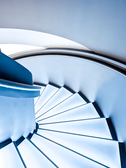 Free A captivating view of a minimalist spiral staircase in soft blue tones. Stock Photo