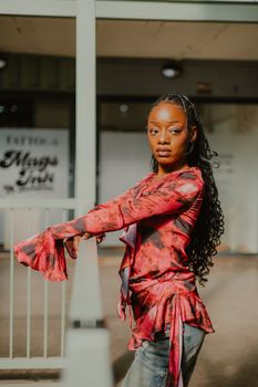 Woman in vibrant attire posing confidently in a Johannesburg urban environment.