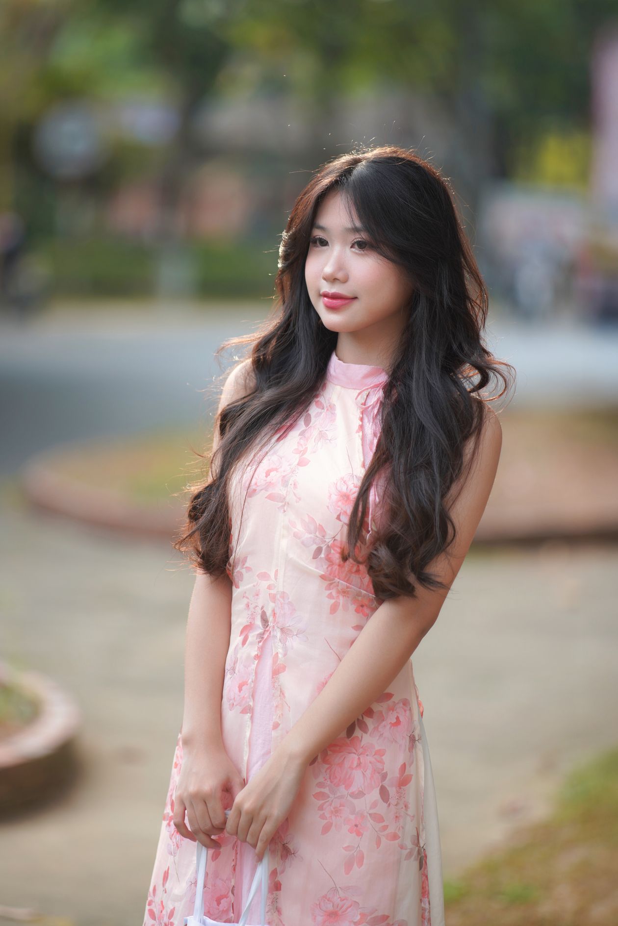 Woman in a sleeveless pink floral dress outdoors