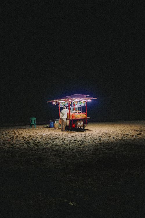 Free Captivating shot of a brightly lit snack stall on a beach in Kozhikode, Kerala. Stock Photo