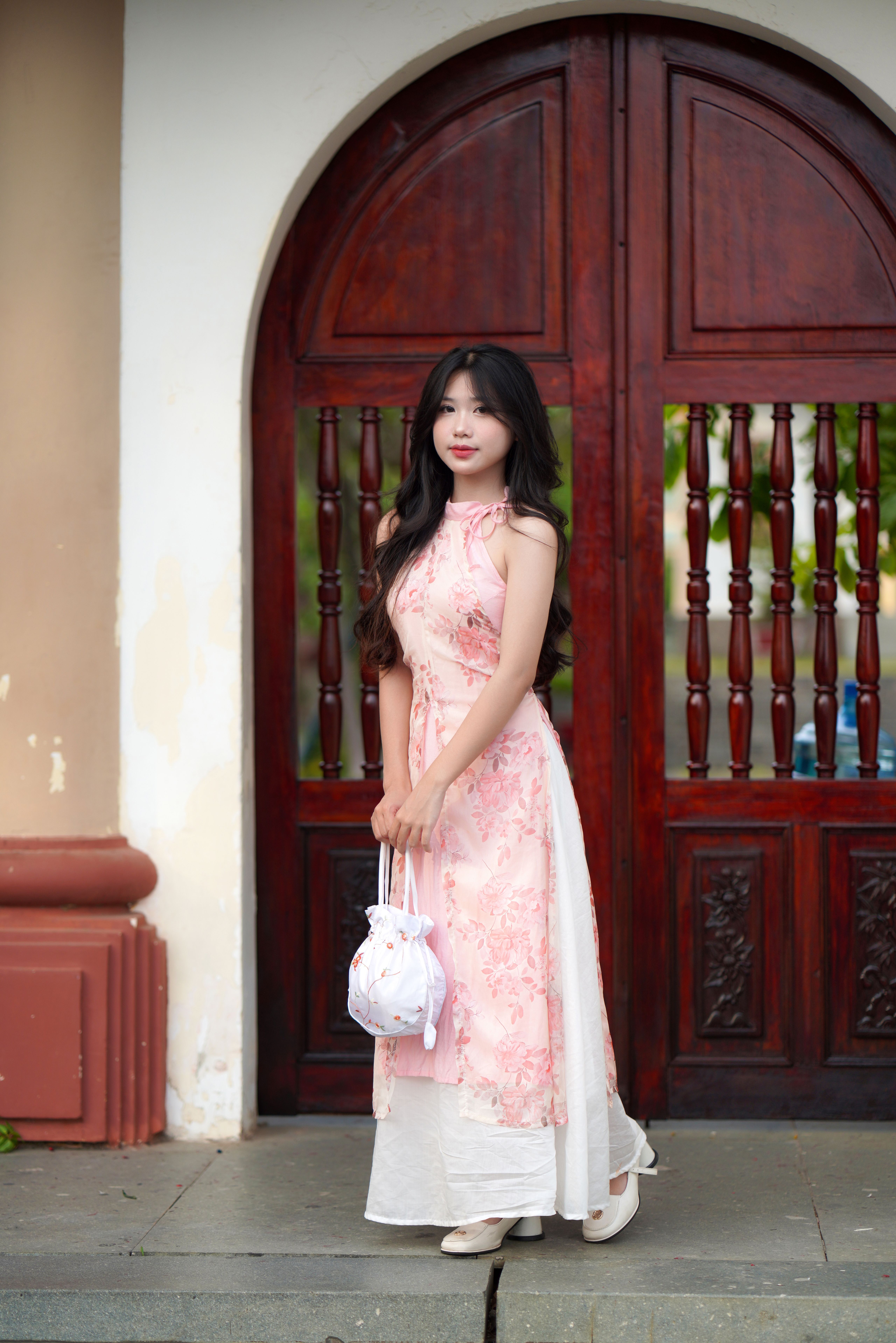 Elegant Woman in Traditional Dress by Wooden Door · Free Stock Photo