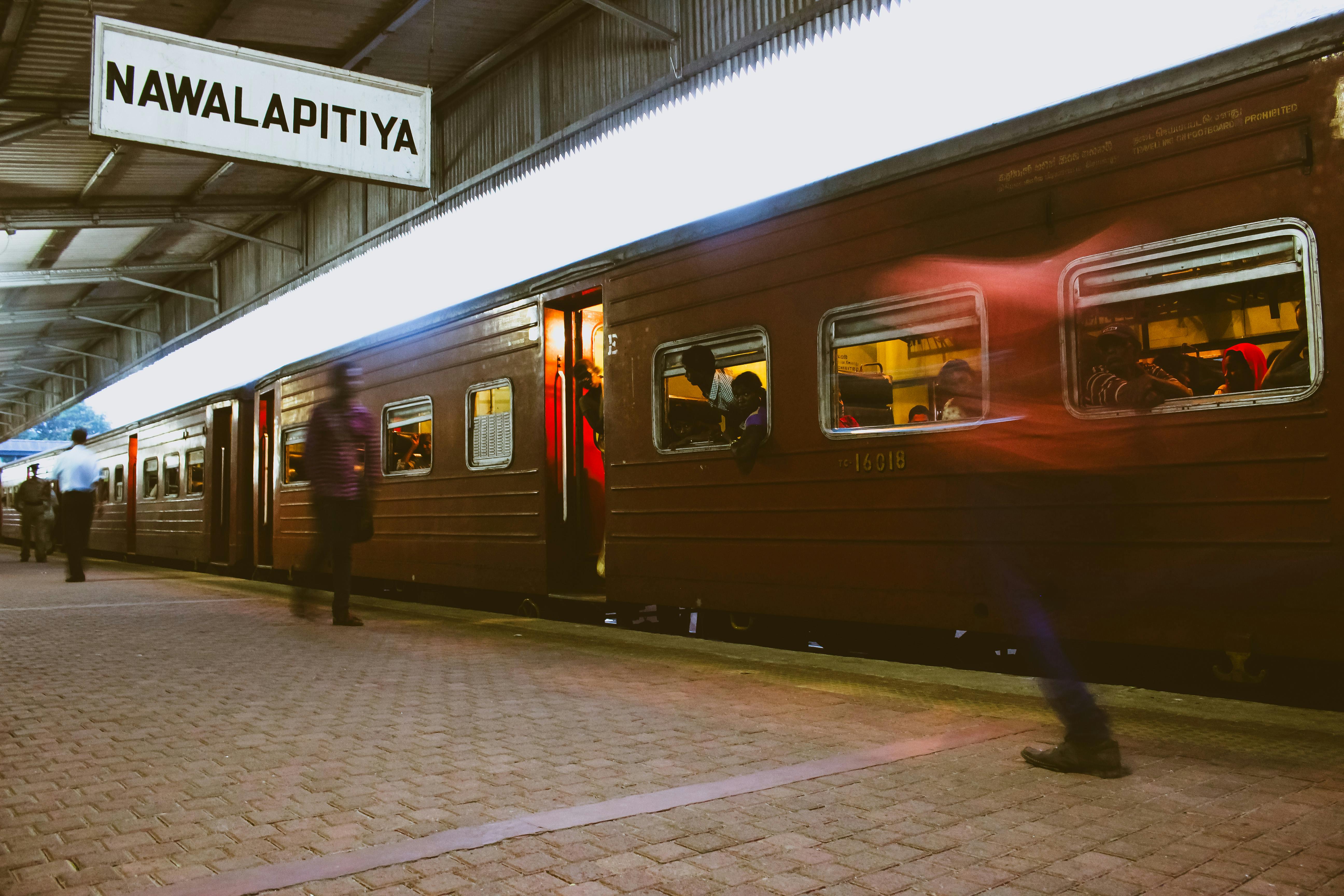 Passengers board a train at Nawalapitiya station in Sri Lanka, capturing vibrant travel moments.