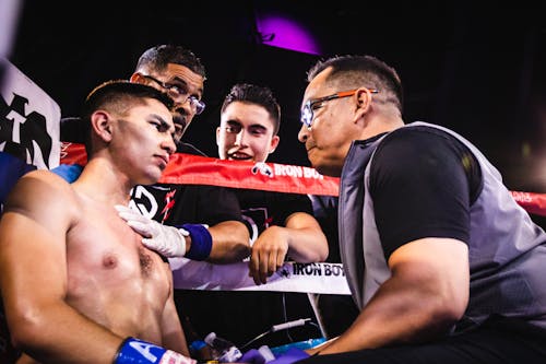 Boxer with trainer and team in ring corner