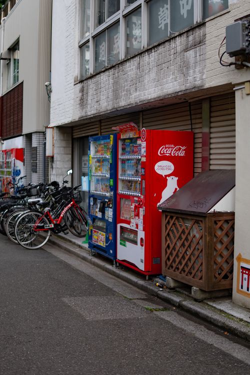 Free Row of vending machines with bicycles on a city street, ideal for urban lifestyle themes. Stock Photo