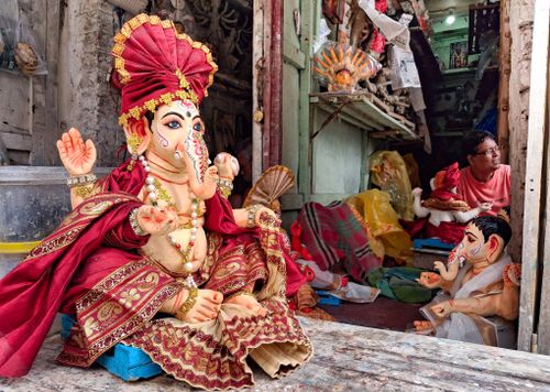 Free Artisan crafting Ganesh idols in a Kolkata workshop, showcasing traditional artistry and vibrant designs. Stock Photo