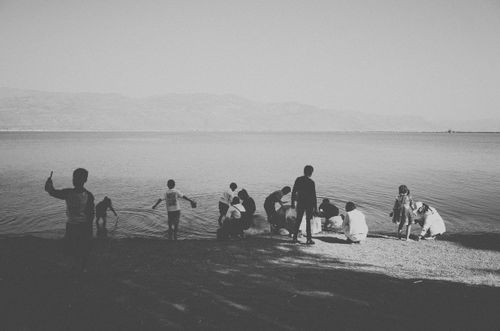 Free A group of people enjoying a serene beach scene in monochrome. Stock Photo