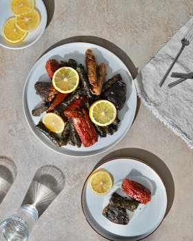 Overhead shot of stuffed vegetables and lemon slices on plates, Mediterranean meal.