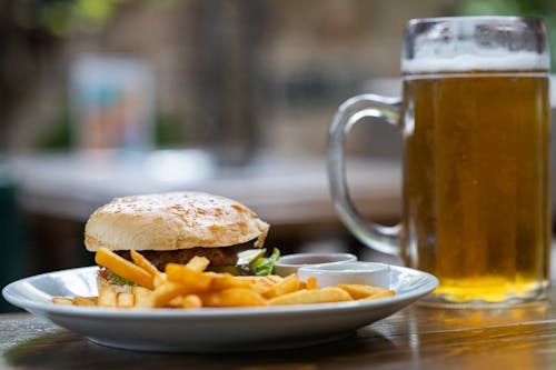 Hamburger and Fries Beside Mug With Beer