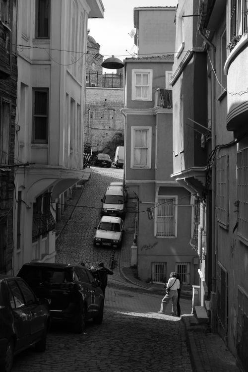 Free Black and white photo of a cobblestone street with parked cars in Istanbul's Beyoglu district. Stock Photo