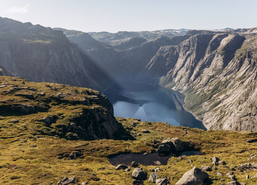 Breathtaking landscape of Trolltunga in Vestland, Norway at daytime, showcasing dramatic cliffs and serene waters.