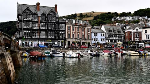 Picturesque view of Dartmouth Harbour with boats and historic buildings reflecting in the water.