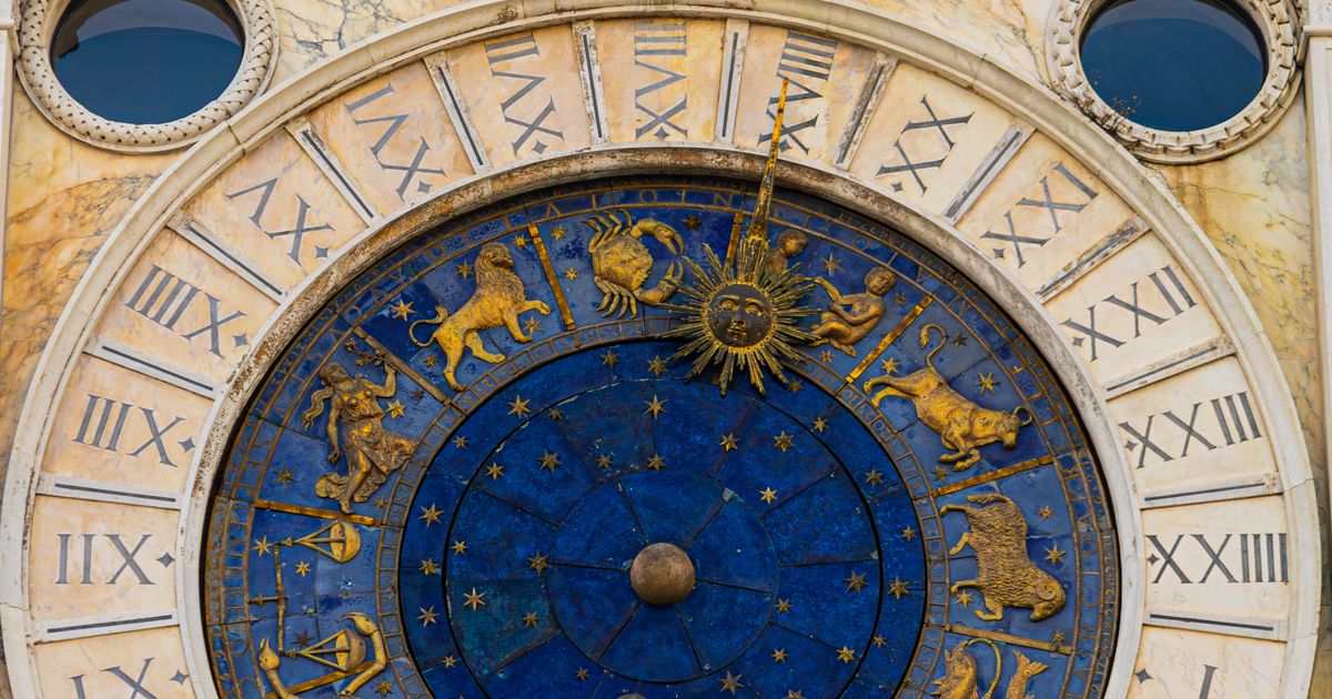 Ancient astronomical clock with the twelve zodiac signs in gold on blue, the fixed twelve-sign wheel behind how daily horoscopes are written