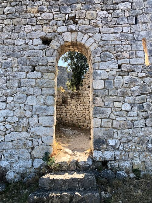 Free A detailed view of an ancient stone archway leading to a historic ruin, highlighting medieval architecture. Stock Photo