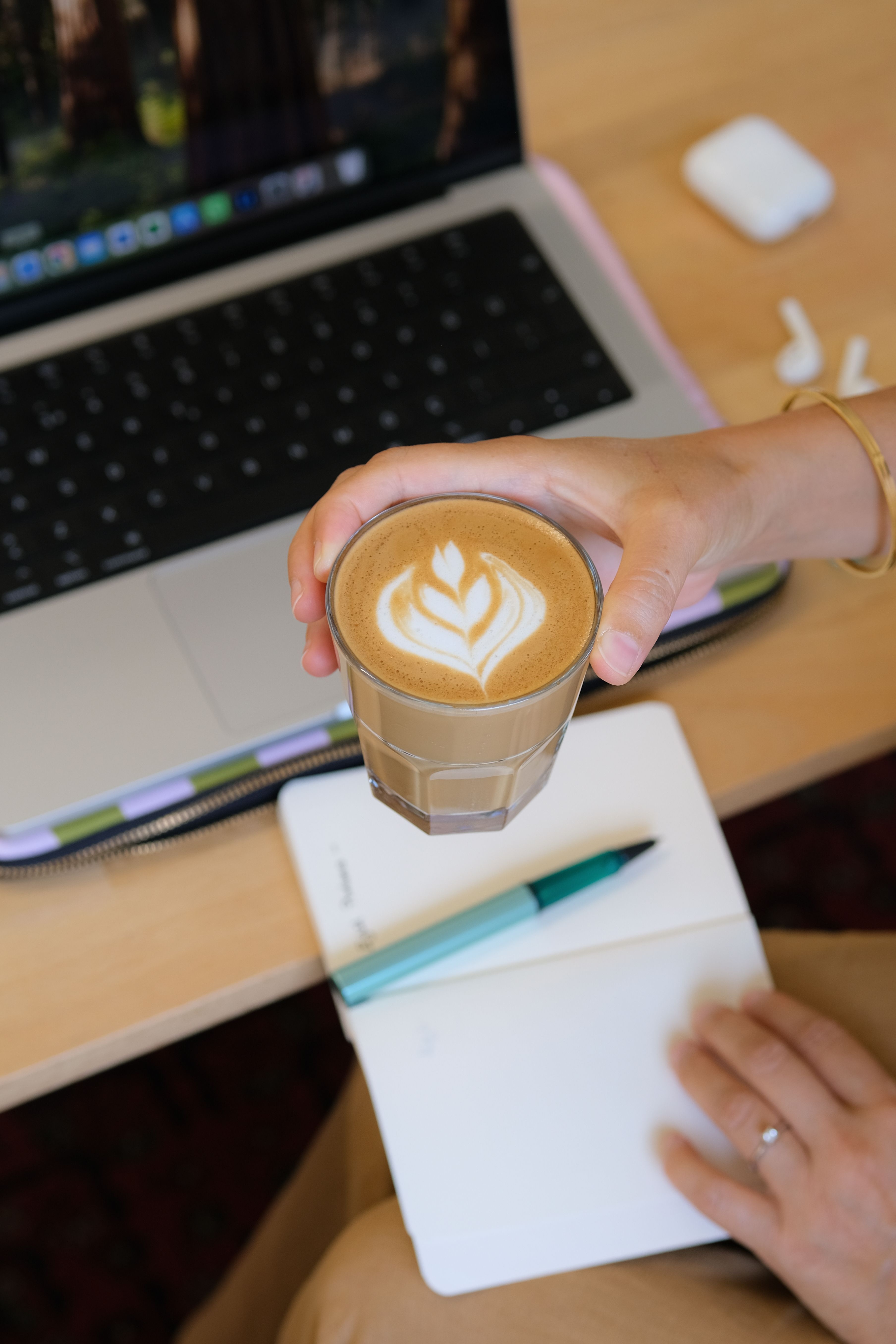 A morning desk with coffee, notebook, and laptop ready before the day begins.