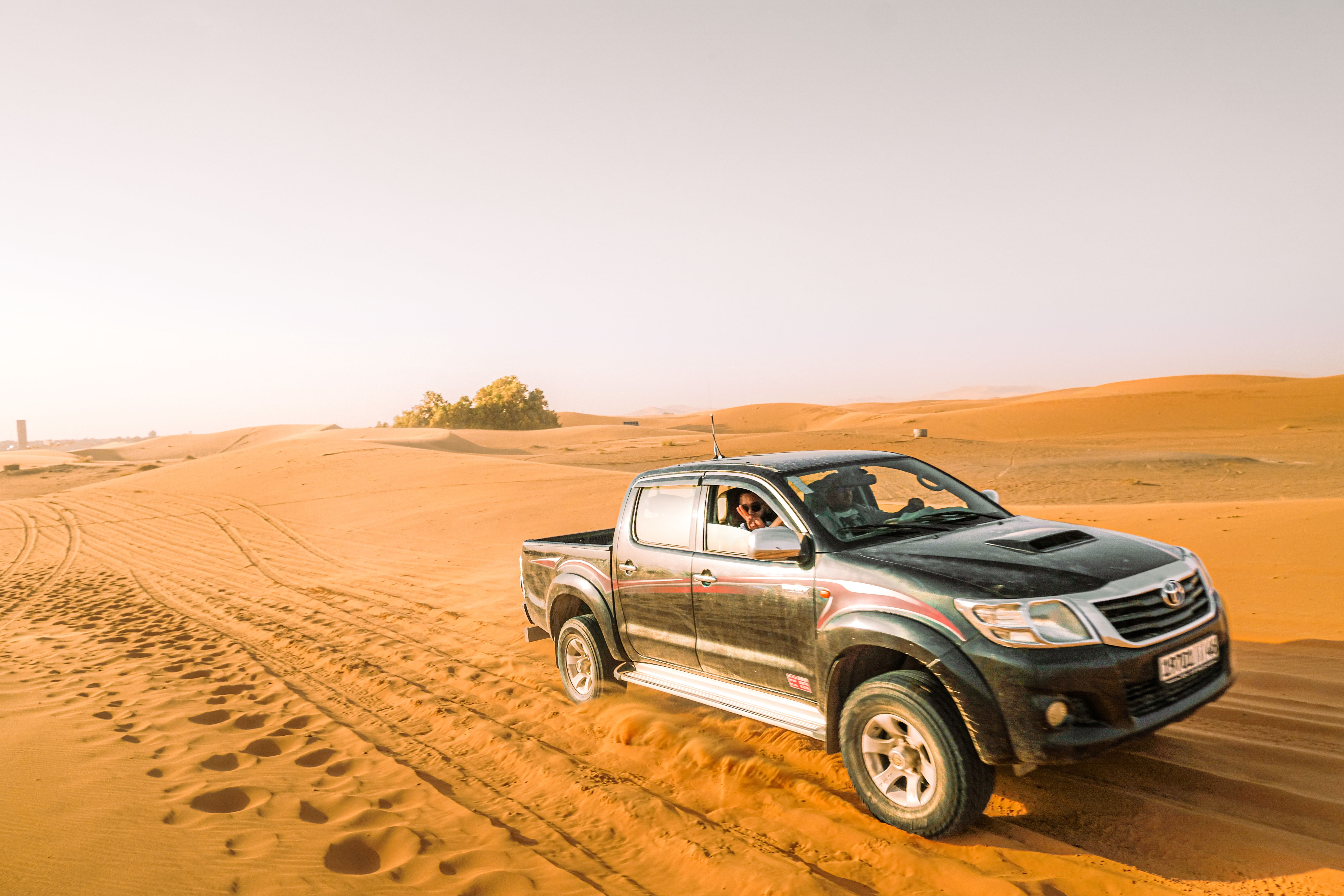 Free Explore the thrill of off-roading in a rugged pickup truck across expansive desert dunes under bright daylight. Stock Photo