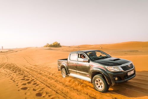 Free Explore the thrill of off-roading in a rugged pickup truck across expansive desert dunes under bright daylight. Stock Photo