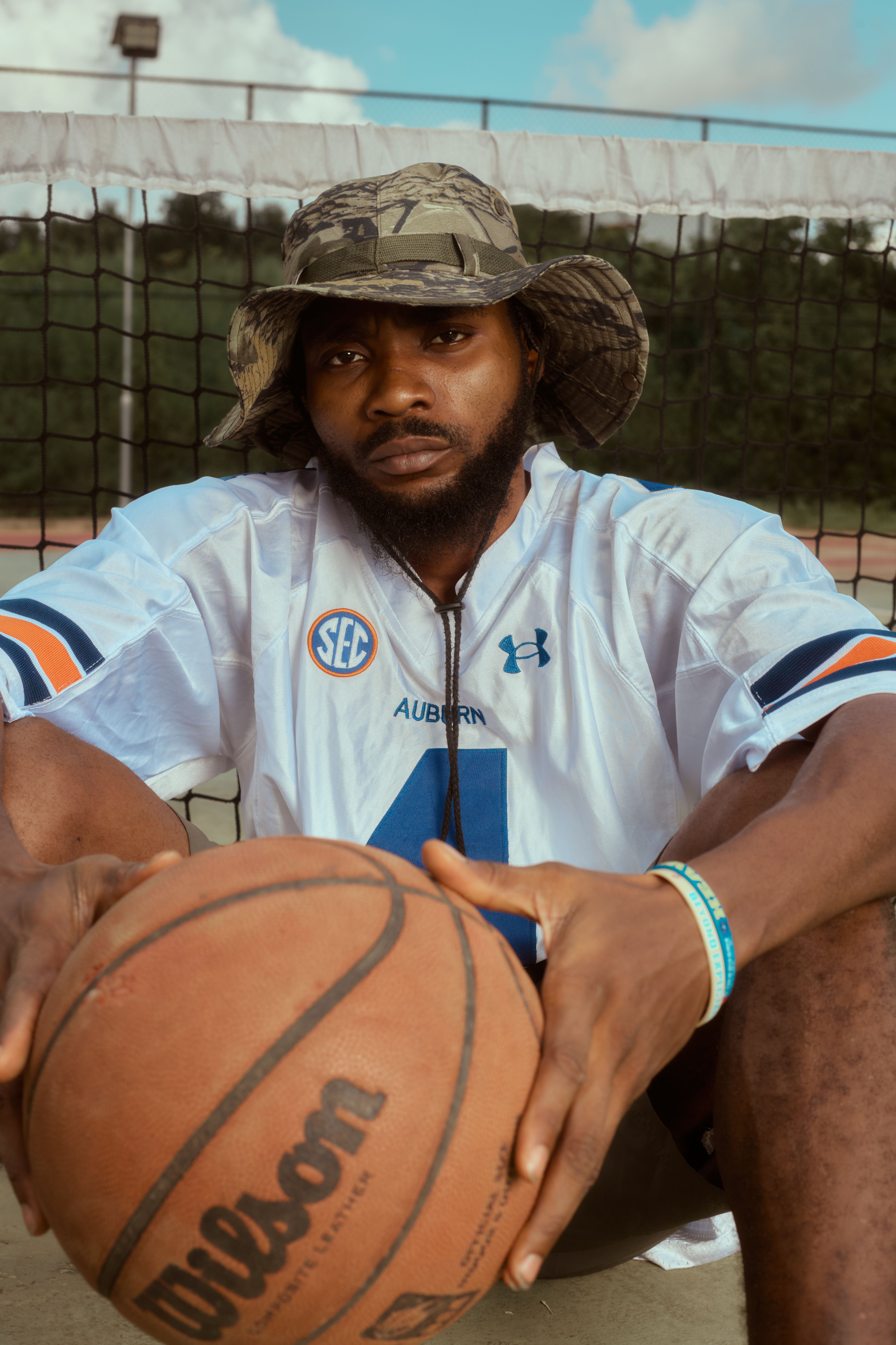 Free Young man in jersey and hat holding a basketball on a court. Stock ...