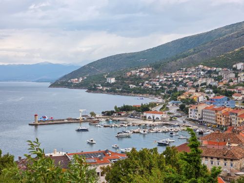 Free Picturesque coastal harbor with boats and hillside town in Croatia. Stock Photo