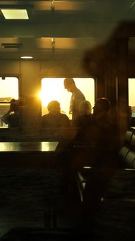 Silhouetted passengers on a train ride during a vibrant sunset, creating a warm ambiance.