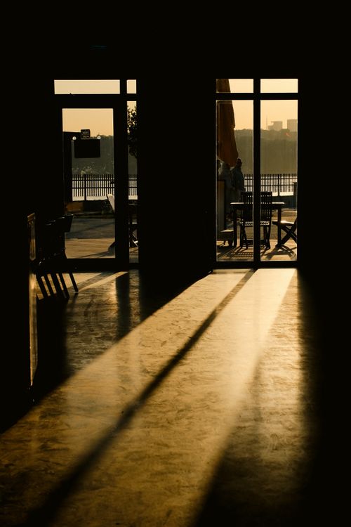 Free Silhouette view through open doors with sunlight casting long shadows indoors. Stock Photo