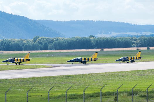 Three L-39 Albatros jets lined up on a runway, preparing for takeoff at Poprad Airport, Slovakia.