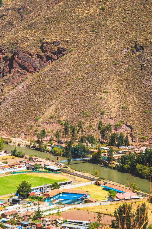 Free Aerial view of the beautiful Cusco Valley with a sports complex and river in Peru, captured during the day. Stock Photo