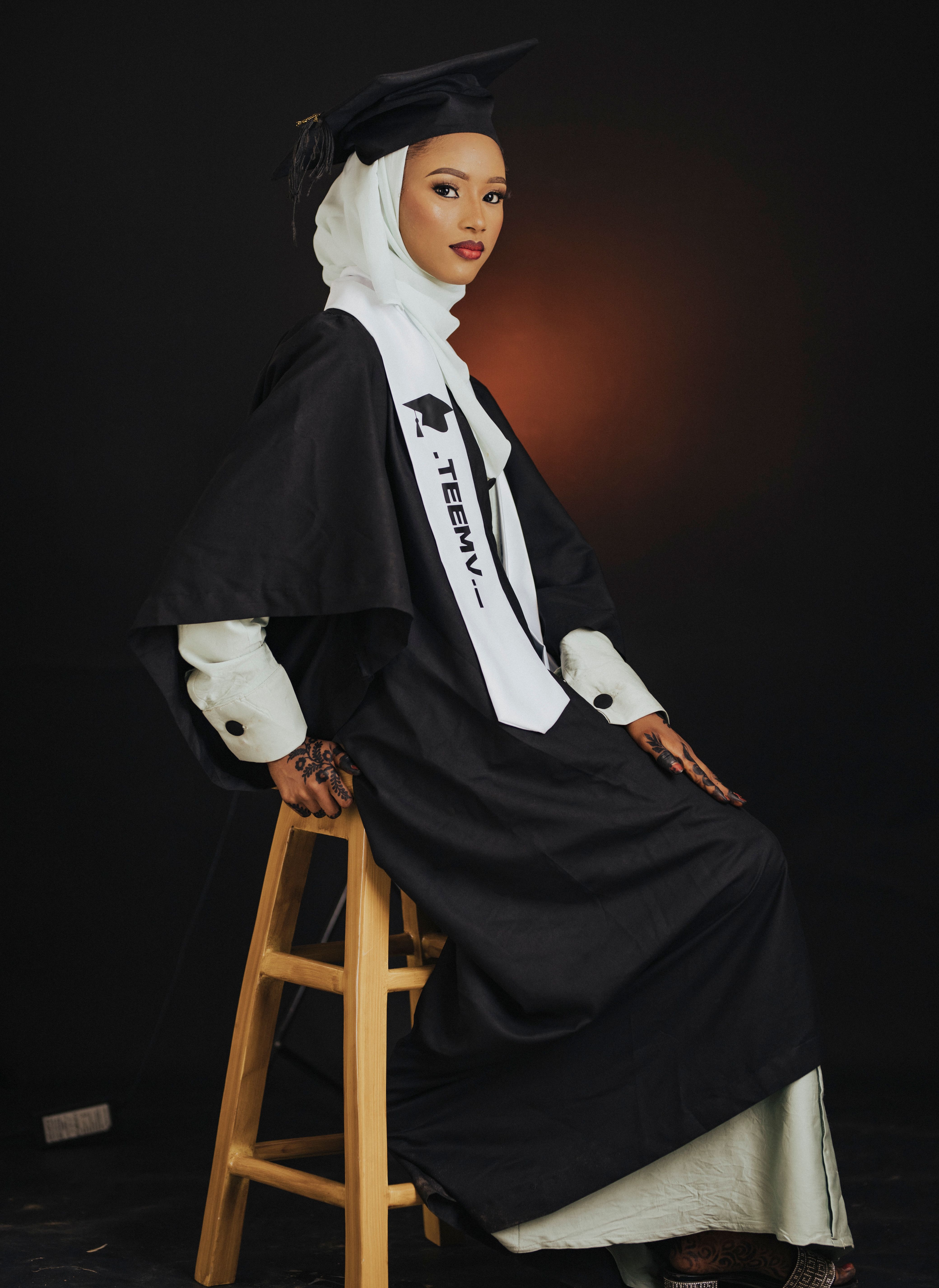Portrait of a female graduate in academic regalia with a confident expression, wearing a hijab, highlighting diversity.