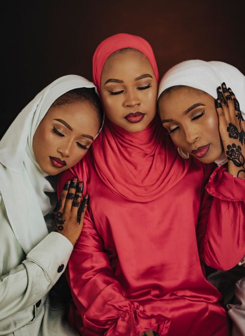Free Three women wearing hijabs pose closely with serene expressions. Elegant and warm. Stock Photo