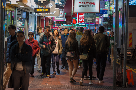 Vibrant street scene capturing nightlife on Hong Kong Island with diverse pedestrians.