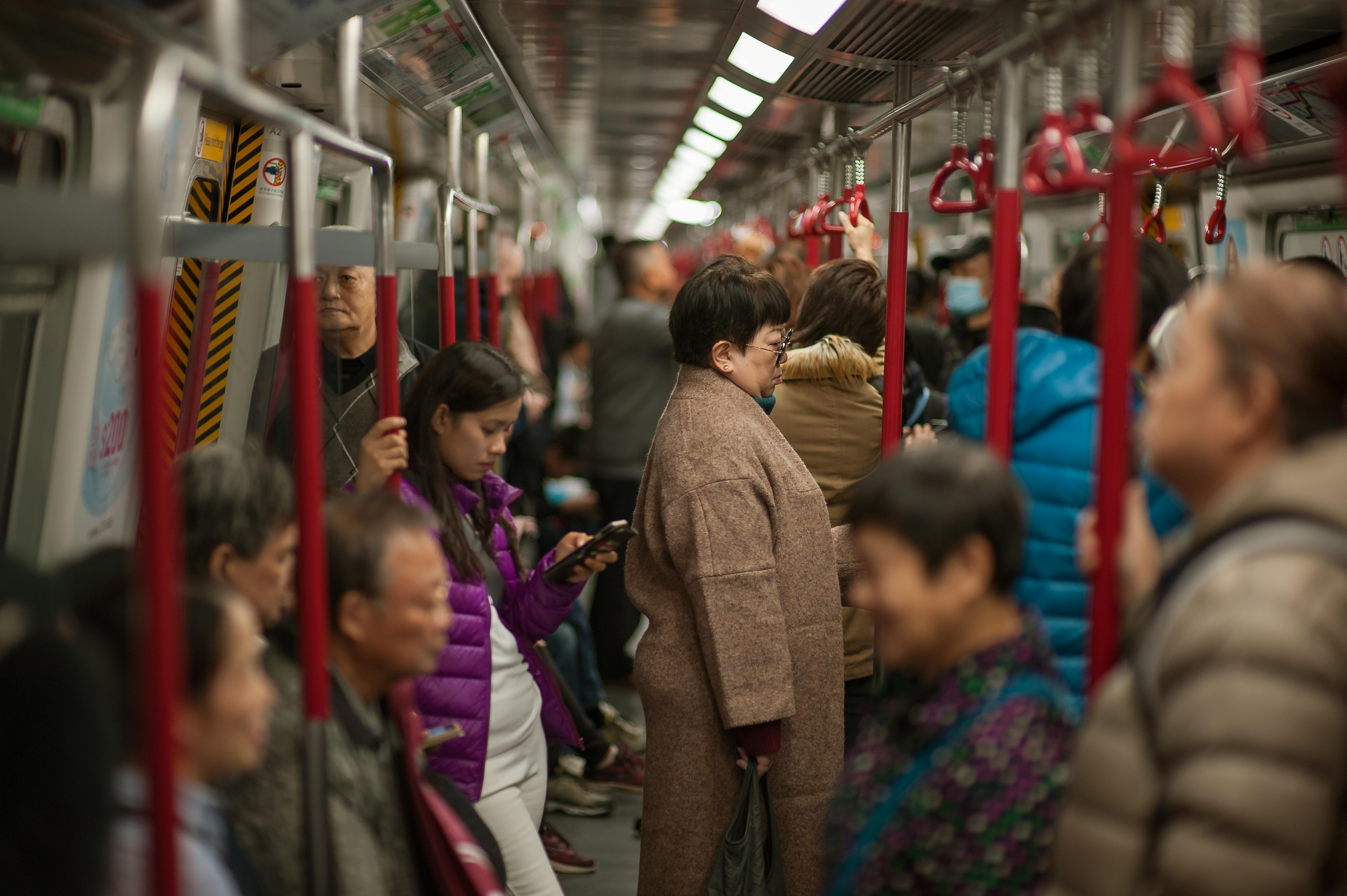 Passengers crowded inside a Hong Kong Island subway carriage during daytime travel.