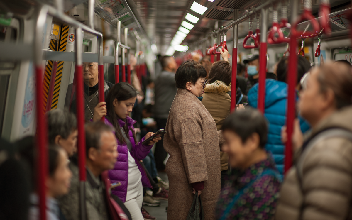 Passengers crowded inside a Hong Kong Island subway carriage during daytime travel.
