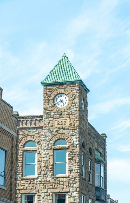 Free Stone clock tower dated 1892 under a clear sky in Holland, Michigan. Stock Photo