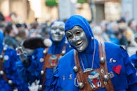 狂欢节游行充满活力，参与者身着蓝色服装和面具，展示着文化庆祝活动