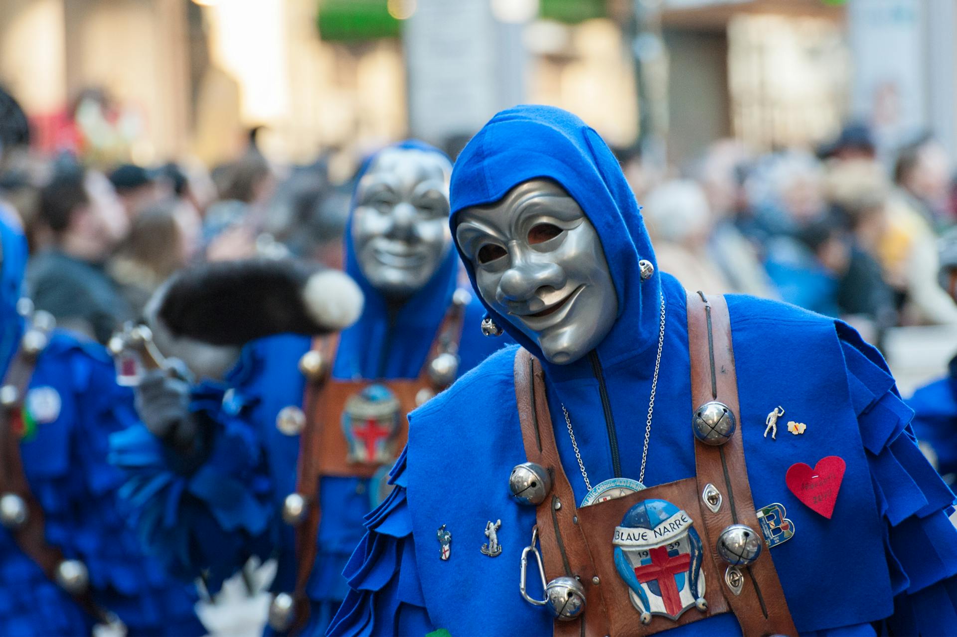 Vibrant carnival parade featuring participants in blue costumes and masks, showcasing cultural festivities.