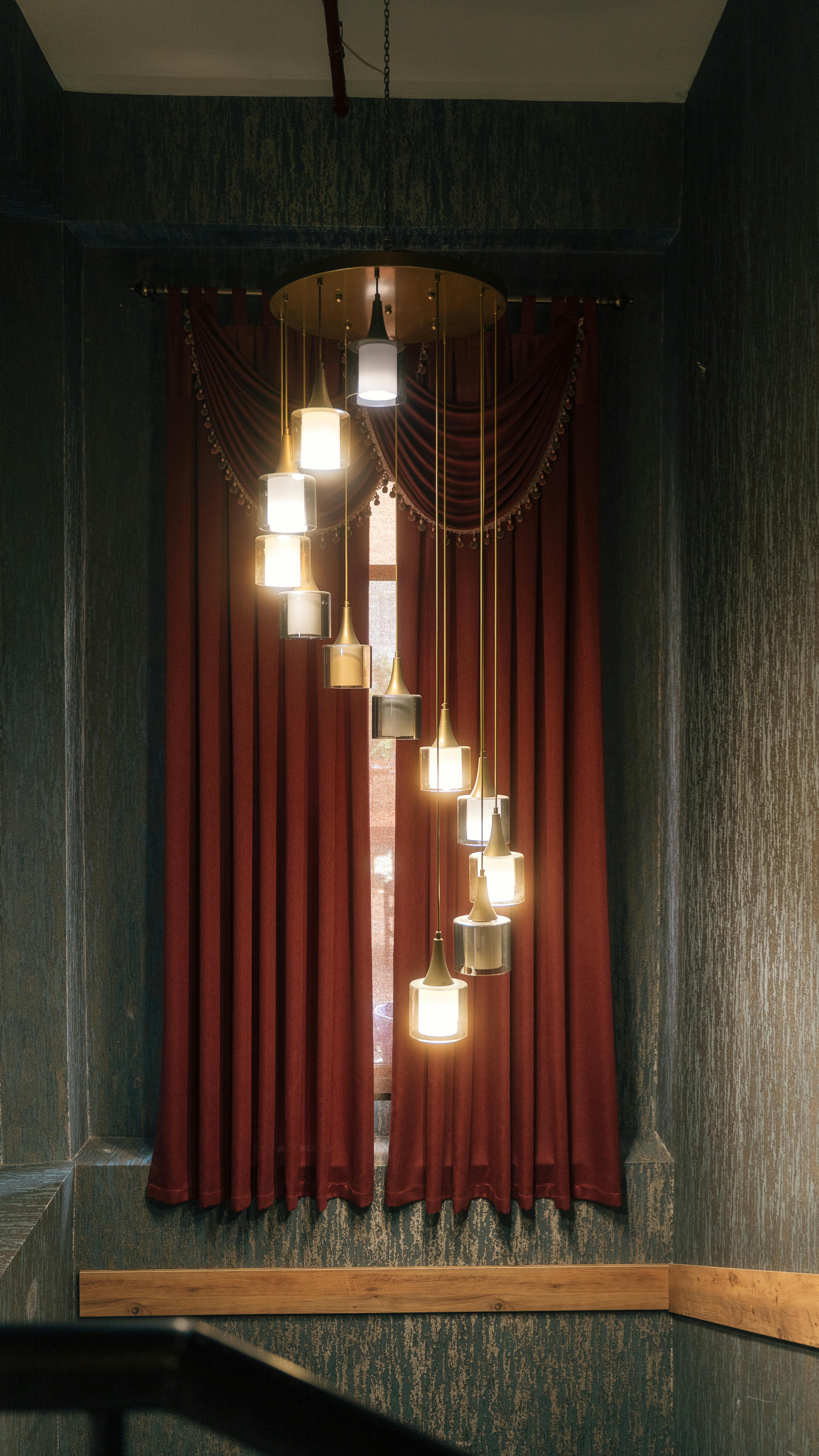 Gratuit Decor interior elegant, cu lămpi suspendate moderne și perdele roșii luxoase, perfect pentru inspirație în design. Fotografie de stoc