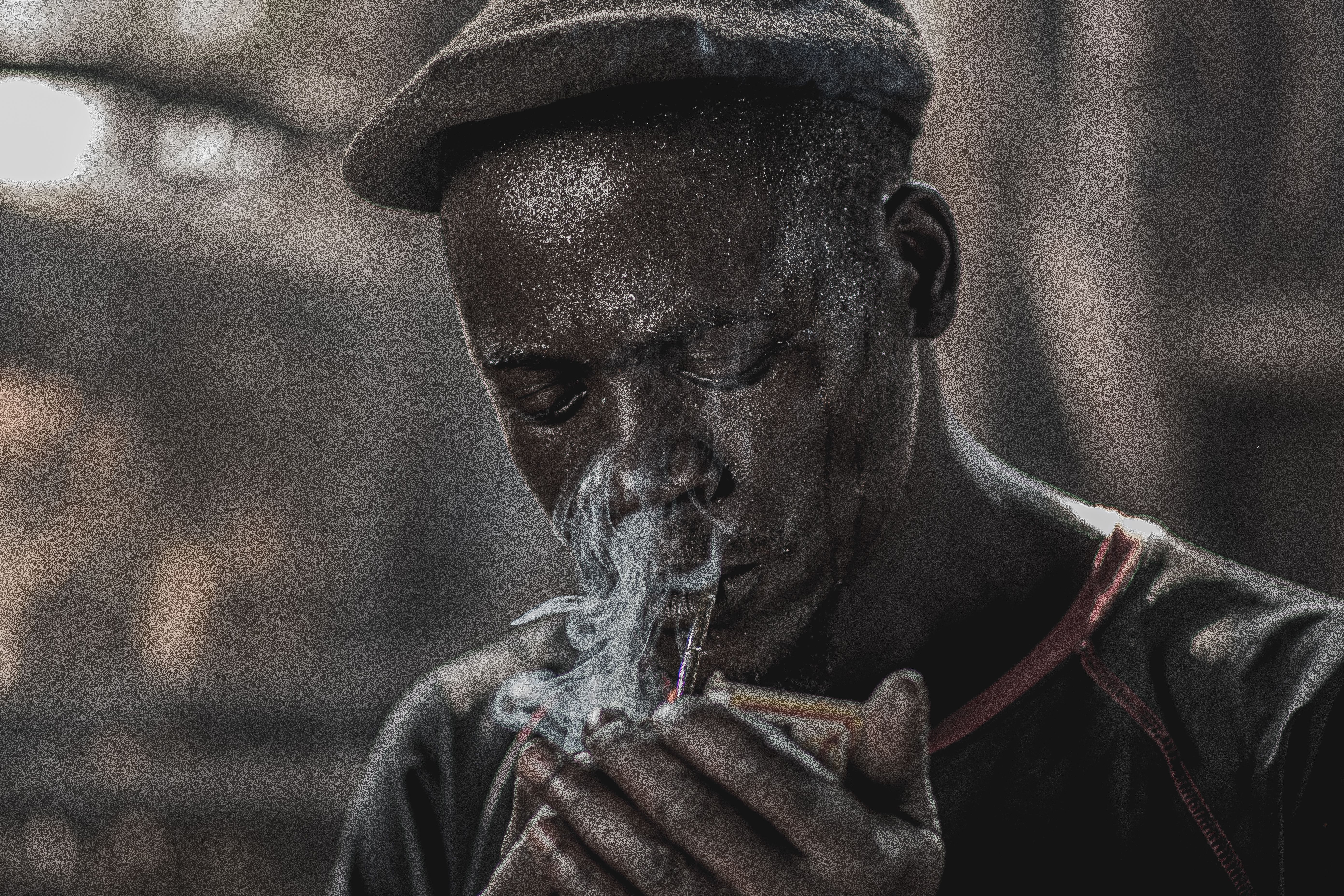 A focused African man lighting a pipe, captured in Nairobi, Kenya, portraying hard work and dedication.