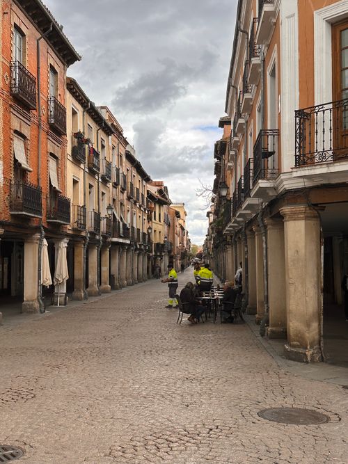 Free A picturesque cobblestone street lined with classic European buildings under a dramatic sky. Stock Photo