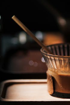 Artistic shot of a pour-over coffee setup focusing on the dripper and wooden tray.