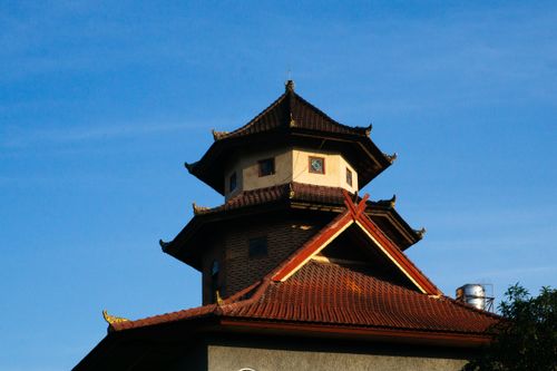 Free A pagoda-style roof of a traditional Balinese building against a clear blue sky. Stock Photo