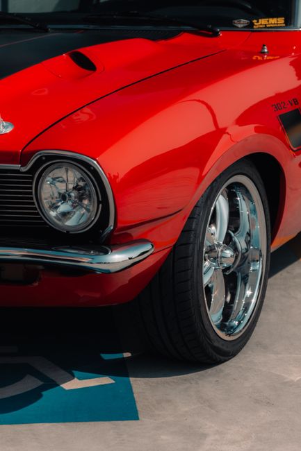 Close-up of a classic red Ford Maverick showcasing shiny chrome details in São Paulo, Brazil.